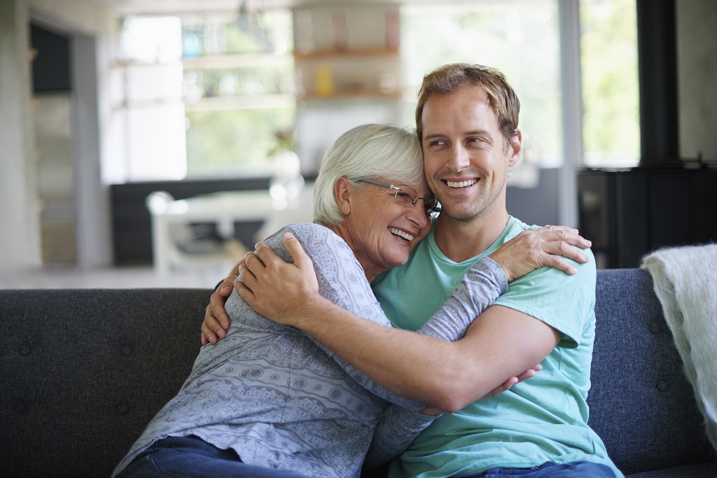 older woman and younger man hugging and smiling