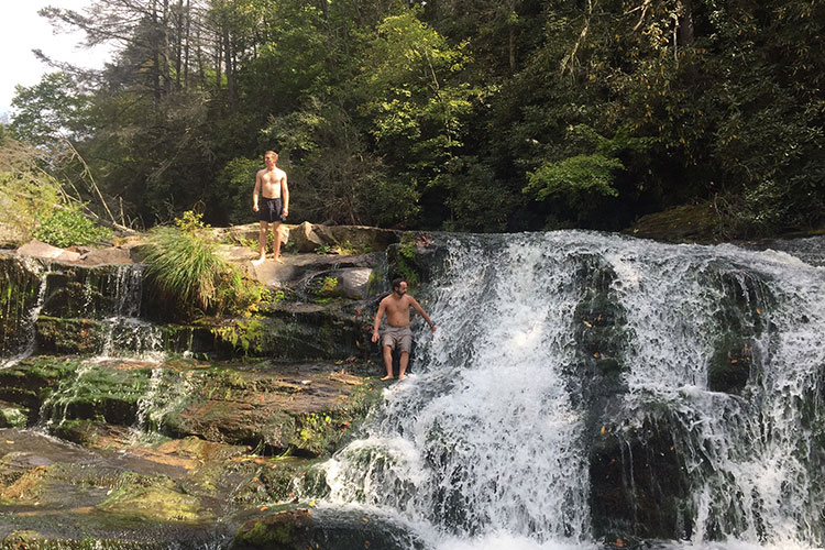 men hiking on waterfall