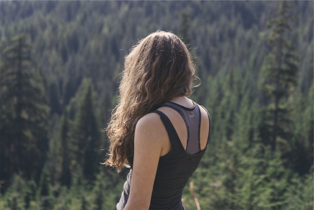 woman overlooking trees on hike