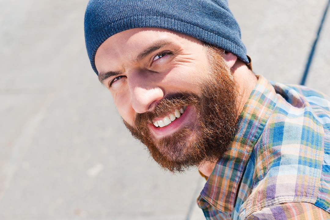 Man wearing beanie smiles