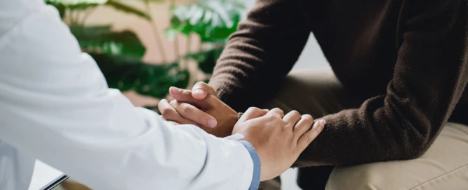 Psychiatrist or professional psychologist holding touching hands patient and comforts an anxious depression patient for medical treatment in diagnostic room, Medical treatment and health care concept.